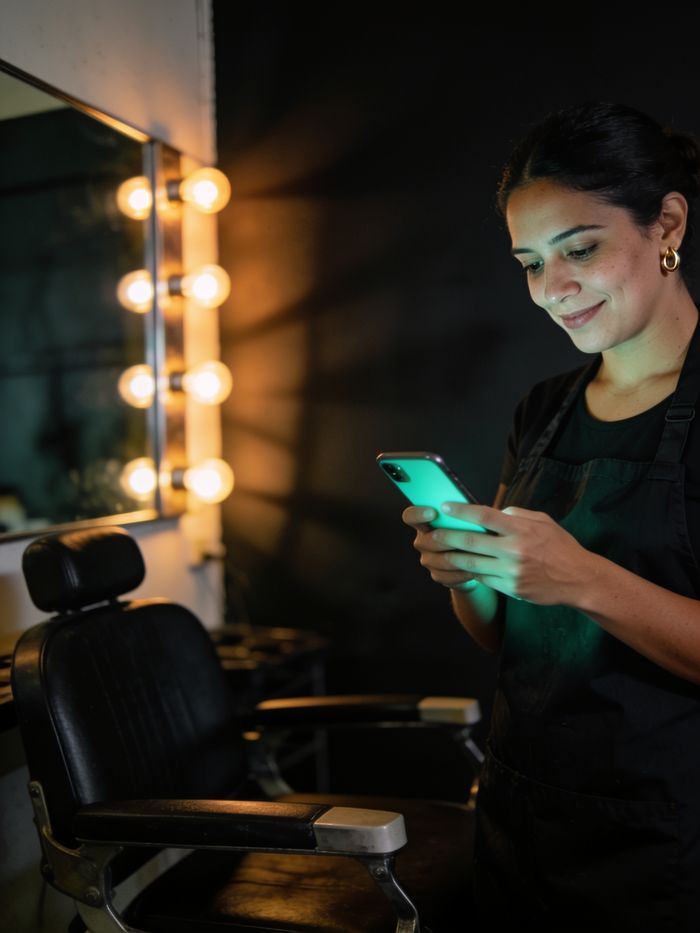 Dueña de un salón de belleza revisando su agenda en el celular
